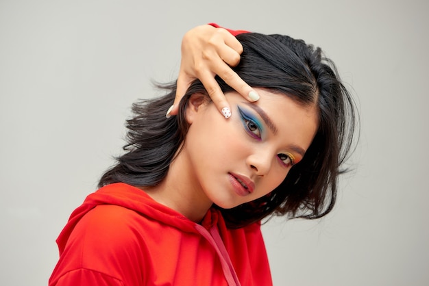 Portrait of a beautiful woman with colorful nails, amazing makeup and dark hairs on white