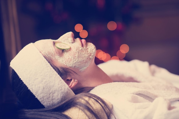 portrait of beautiful woman with cosmetic mask on face in spa and  wellness salon