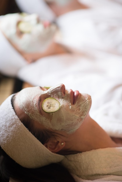 Foto ritratto di bella donna con maschera cosmetica sul viso nel salone spa e benessere