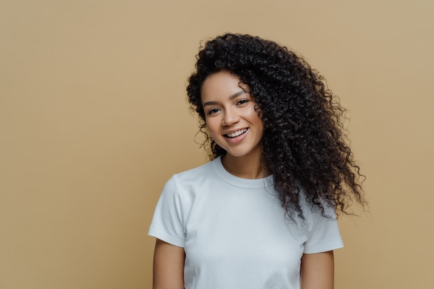 Portrait of beautiful woman with frizzy bushy hair gently smiling