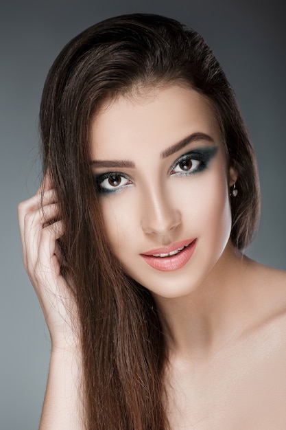 portrait of a beautiful woman with a green evening make-up on a dark background