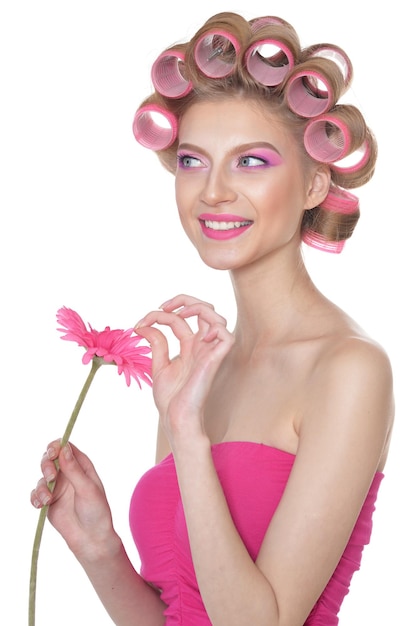 Portrait of beautiful woman with hair curlers holding flower