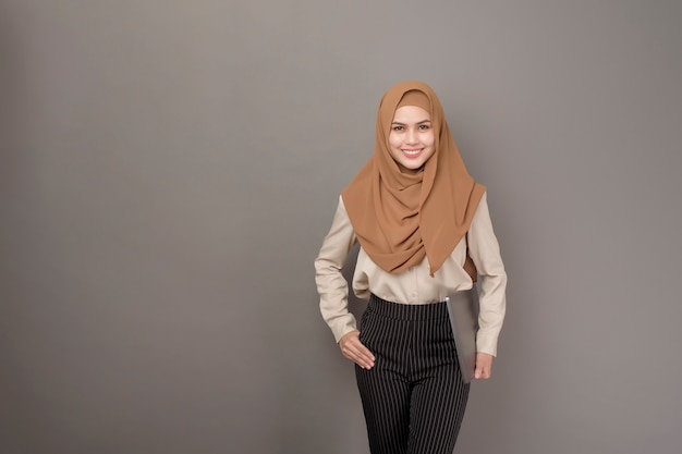 Hijab와 아름 다운 여자의 초상화는 컴퓨터 노트북을 들고있다