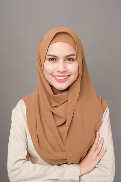 Portrait of beautiful woman with hijab is smiling on gray background