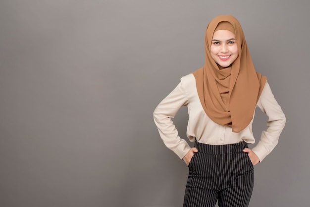 Портрет красивой женщины с хиджабом улыбается на сером фоне