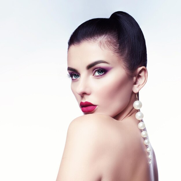 Portrait of a beautiful woman with jewelry and evening makeup.\
brunette with styling for the holiday. fashion for beauty.