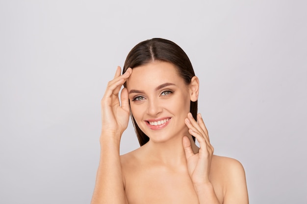 Portrait of beautiful woman with natural make up touching her face. 