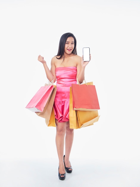 Portrait of beautiful woman with shopping bags and smartphone on white surface, space for text
