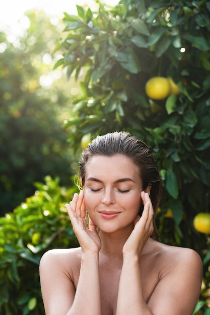 Portrait of beautiful woman with smooth skin against lemon trees