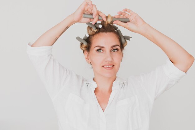 Portrait of a beautiful woman witn a hair curlers on white background.