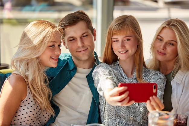 Ritratto di belle donne che catturano foto sul telefono cellulare