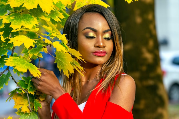 Портрет красивой молодой африканской женщины на осенних листьях