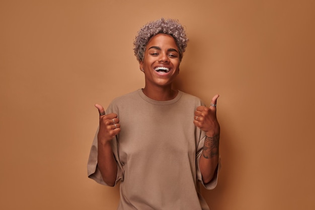 Portrait of beautiful young african woman smiling with thumbs up hand gesture