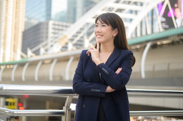 Portrait of beautiful young asian business woman is working in modern city