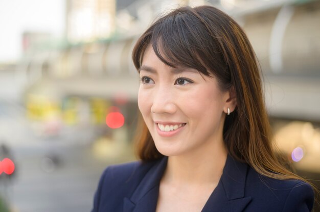 美しい若いアジアのビジネスウーマンが現代の都市で働いている肖像画