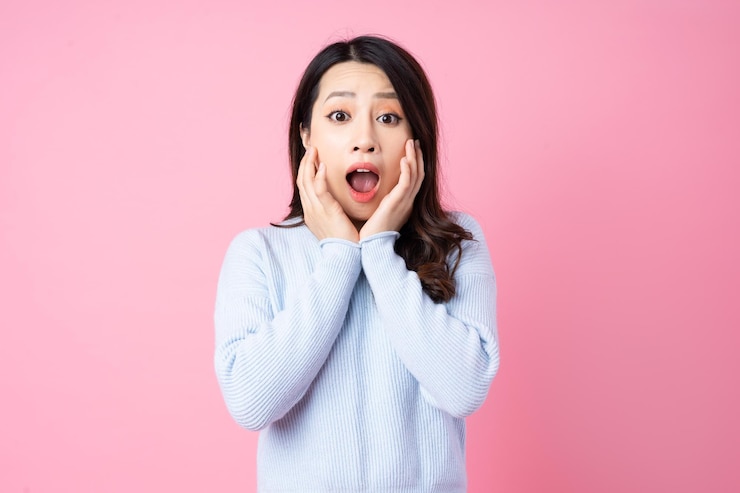 Photo ピンクの背景に分離された美しい若いアジアの女の子の肖像画