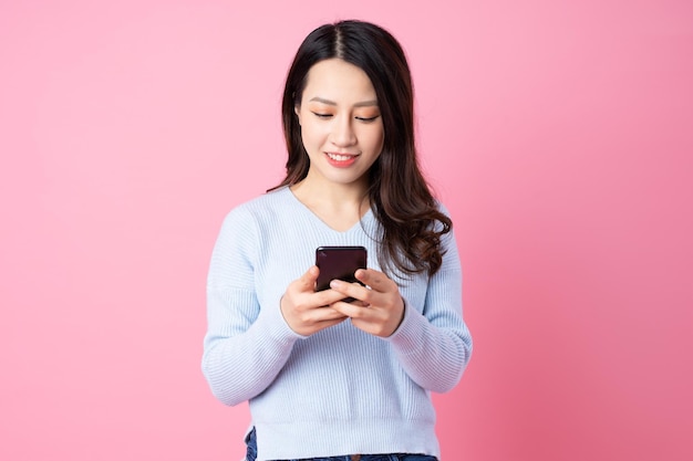 Portrait of a beautiful young Asian girl, isolated on pink background