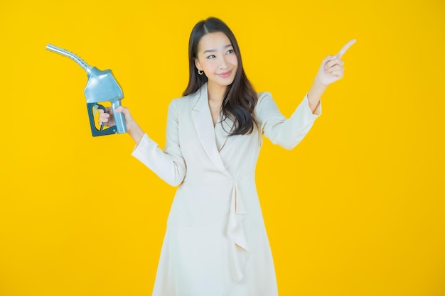 Portrait beautiful young asian woman feul gas pump on color background