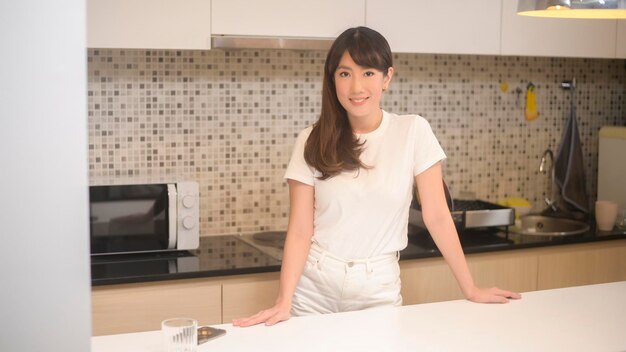 Портрет красивой молодой азиатской женщины на кухне