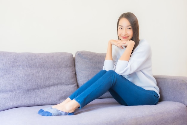 Portrait beautiful young asian woman relax smile on sofa in living room