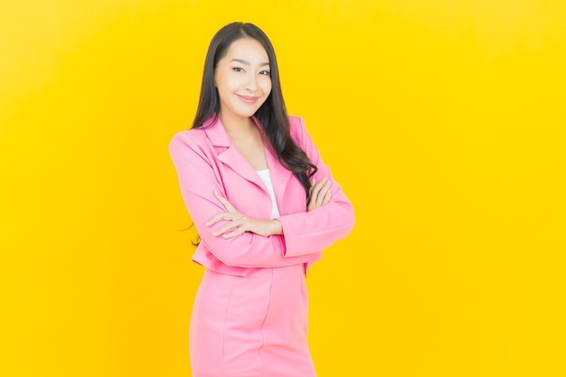 Portrait beautiful young asian woman smile with action on yellow color wall