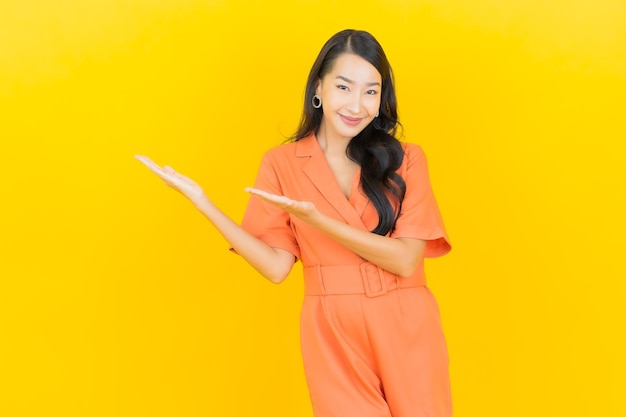 Portrait beautiful young asian woman smile with action on yellow