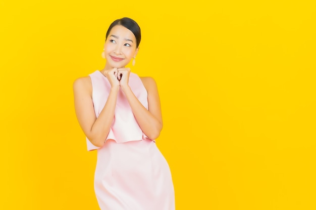 Portrait beautiful young asian woman smile with action on yellow