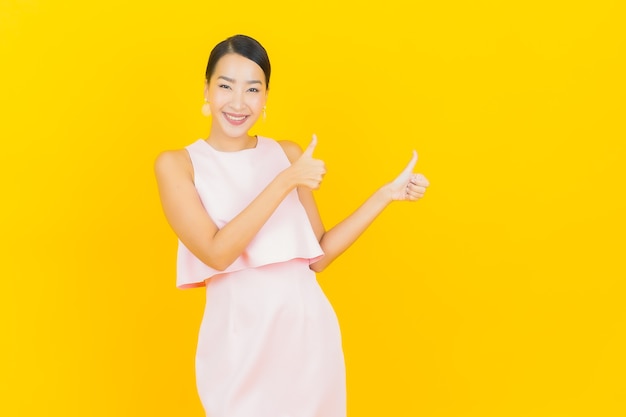 Portrait beautiful young asian woman smile with action on yellow