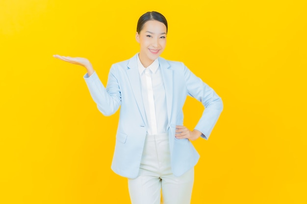 Portrait beautiful young asian woman smile with action on yellow