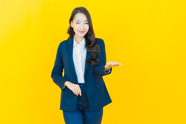 Portrait beautiful young asian woman smile with action on yellow