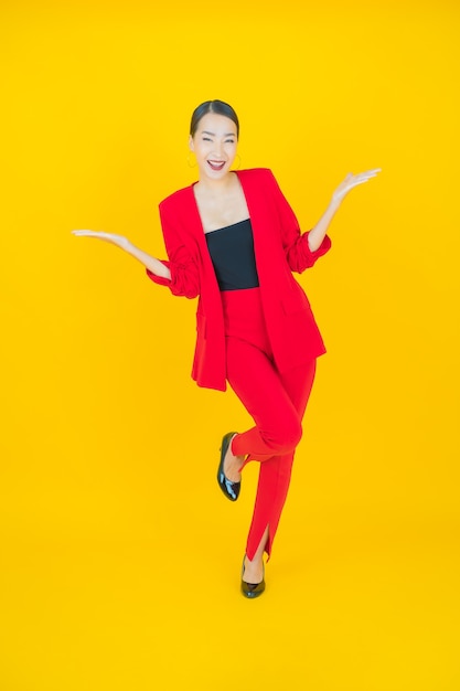 Portrait beautiful young asian woman smile with action on yellow