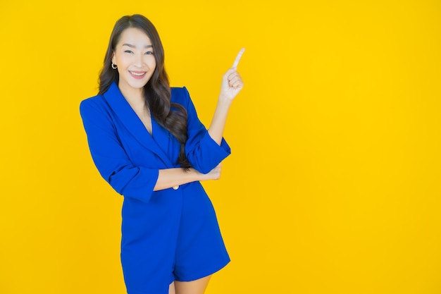 Portrait beautiful young asian woman smile with action on yellow