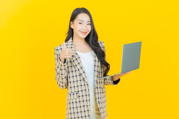 세로 컴퓨터 노트북으로 아름 다운 젊은 아시아 여자 미소