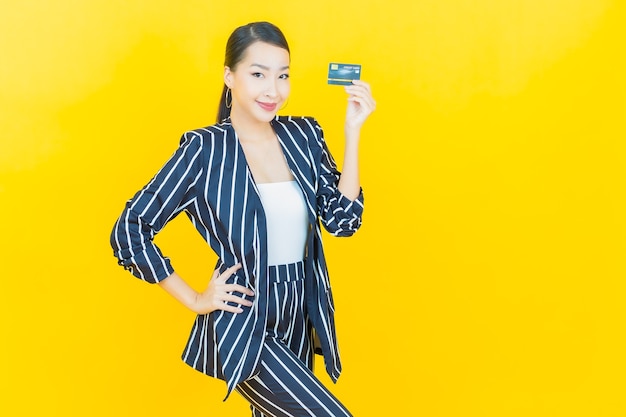 Portrait beautiful young asian woman smile with credit card on color background