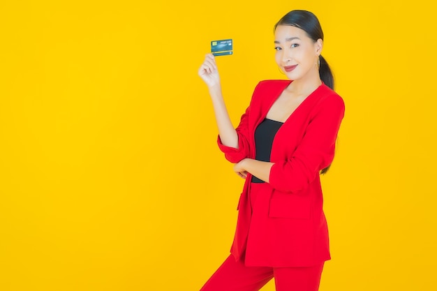 Portrait beautiful young asian woman smile with credit card on yellow