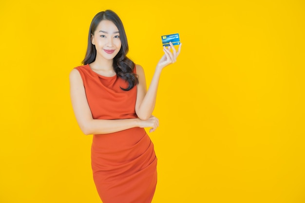 Portrait beautiful young asian woman smile with credit card on yellow