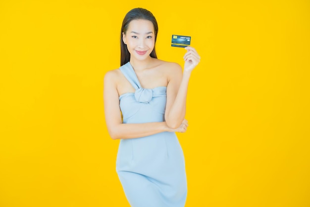 Portrait beautiful young asian woman smile with credit card on yellow