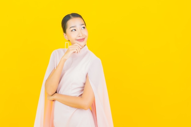 Photo portrait beautiful young asian woman smile with many action on yellow wall