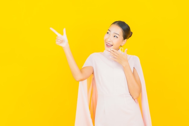 Photo portrait beautiful young asian woman smile with many action on yellow wall