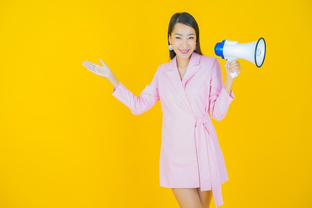 Portrait beautiful young asian woman smile with megaphone on color background