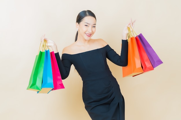 Portrait beautiful young asian woman smile with shopping bag on yellow