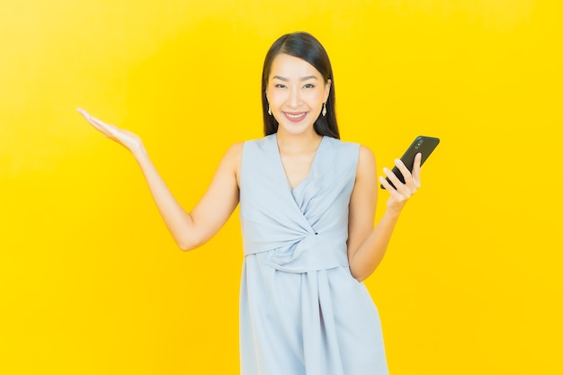 肖像画美しい若いアジアの女性がスマートな携帯電話で笑顔