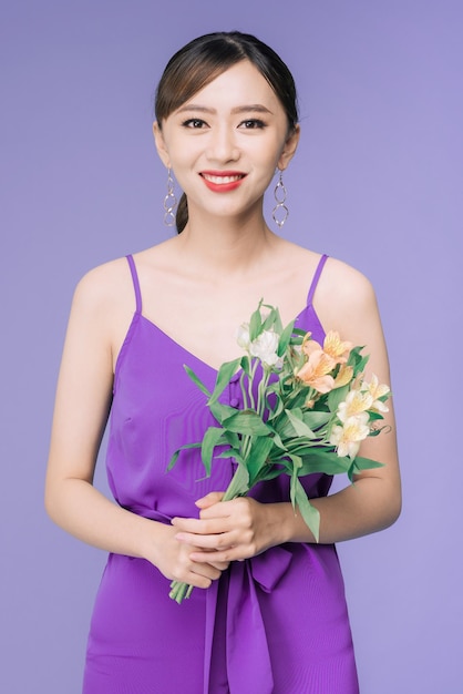 Portrait of beautiful young asian woman over violet background