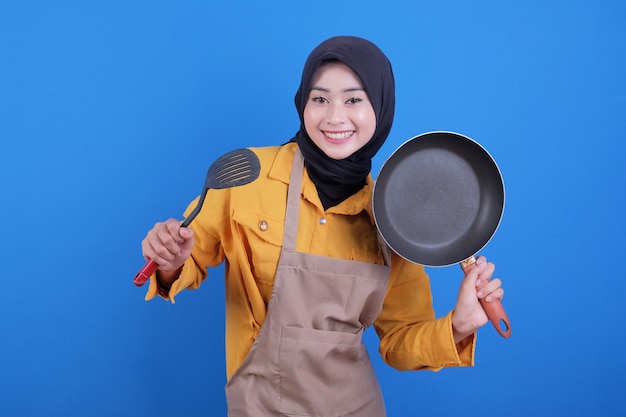 Portrait beautiful young asian woman wear apron with black pan and spatula