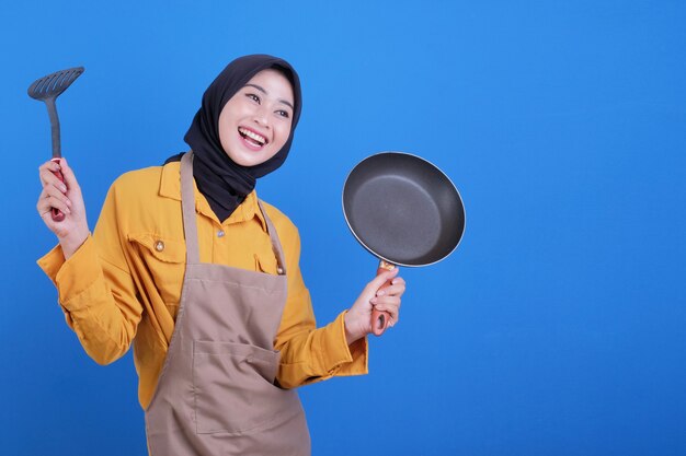 Portrait beautiful young asian woman wear apron with black pan