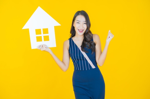 Portrait beautiful young asian woman with house or home paper sign on