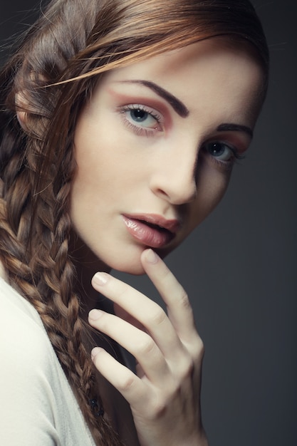 Portrait of beautiful young blonde woman with creative braids ha