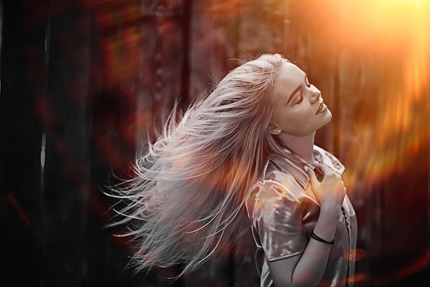 Portrait of a beautiful young blonde woman with sun rays and glare