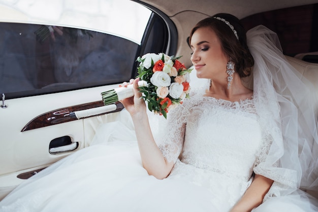 Portrait of a beautiful young bride in the car