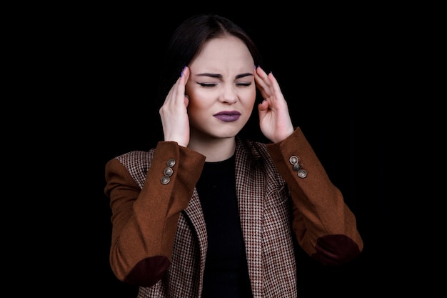 Portrait of beautiful young brunette wore a white sweater touching her temples